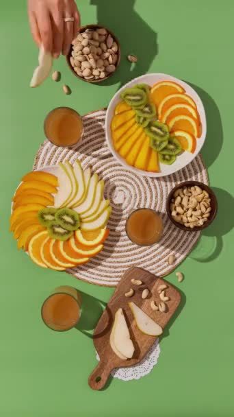 Fruktnötsnacks på det gröna bordet. Människor hemma tillsammans, äter hälsosam mat. Ovanifrån platt låg familj matsal — Stockvideo