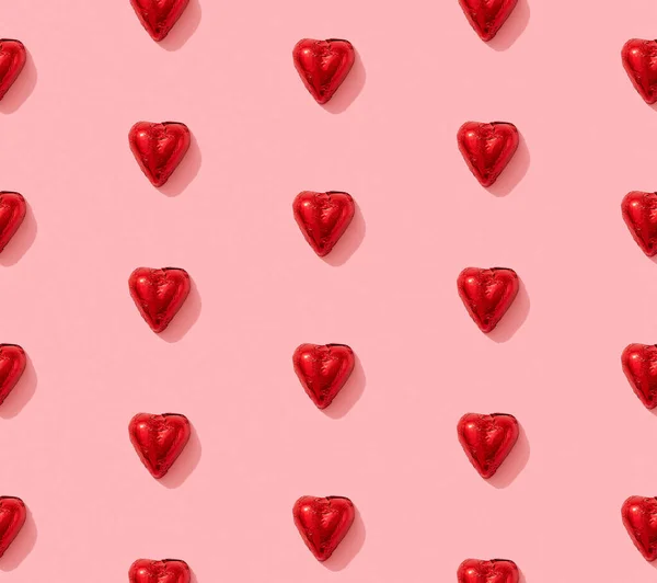Tarjeta de felicitación de San Valentín con caramelos de chocolate en forma de corazón sobre fondo rosa. Día de San Valentín romántica celebración diseño creativo — Foto de Stock