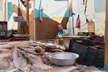 HURGHADA, EGYPT - 19 Şubat 2022: Yerel balık satıcısı pazarda oturuyor. Balık pazarında taze yakalanmış balıklar