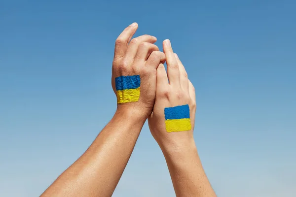 Female and male hands painted in Ukraine flag colors holding. Stop the war — Stock Photo, Image