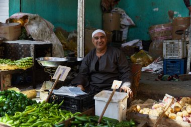 HURGHADA, EGYPT - 20 Şubat 2022: Yerel satıcı pazarda oturuyor. Sokak pazarında taze sebzeler.