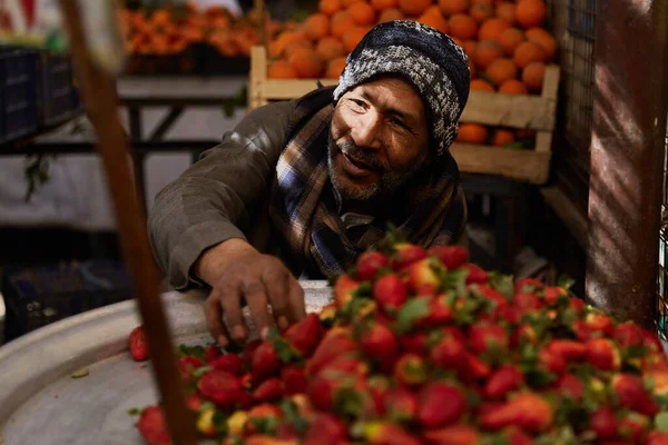 HURGHADA, EGYPT - LUTY 20, 2022: Lokalny sprzedawca siedzi na rynku. Świeże owoce na bazarze ulicznym — Zdjęcie stockowe