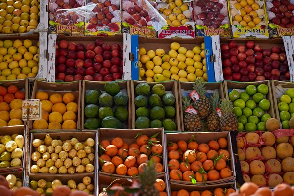 HURGHADA, EGITO - FEVEREIRO 20, 2022: Maçãs, manga, mamão, mandarina, goiaba, abacaxi em caixas no balcão do autêntico mercado egípcio. Frutos frescos no bazar de rua — Fotografia de Stock