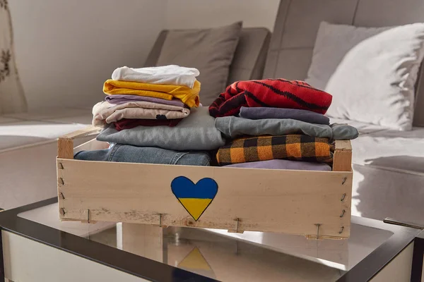 Gönüllü bağış konsepti. Evde giysi dolu bir bağış kutusu.