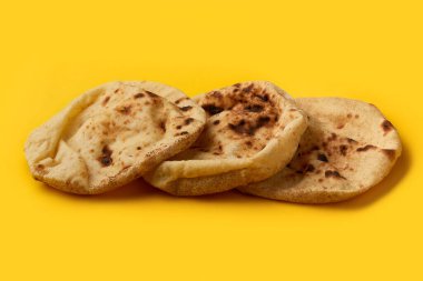 Mısır ekmeği Aish Baladi üzerinde. Sarı masada bir sürü taze ekmek yatıyor.