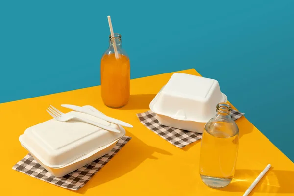 Lancheiras, talheres e bebidas na mesa laranja. Conceito de entrega de alimentos — Fotografia de Stock