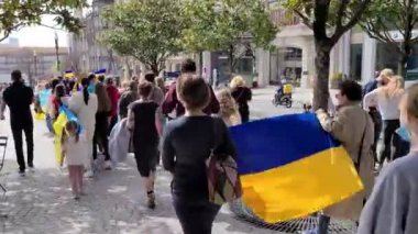 Porto, Portekiz, 27 Mart 2022. Elinde bayraklar ve Ukrayna bayrakları bulunan bir Ukraynalı gösterici, müdahaleyi protesto etti. Savaş karşıtı protesto şehir merkezinde