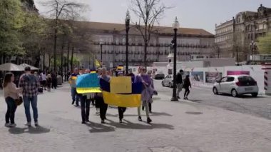 Porto, Portekiz, 27 Mart 2022. Elinde bayraklar ve Ukrayna bayrakları bulunan bir Ukraynalı gösterici, müdahaleyi protesto etti. Savaş karşıtı protesto şehir merkezinde