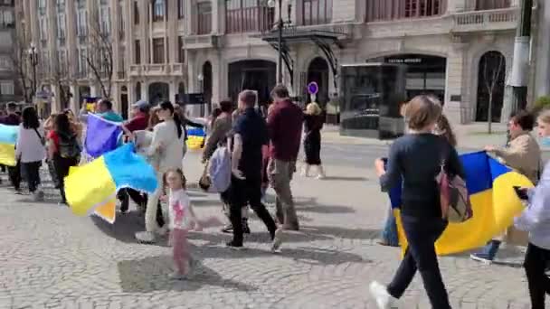 Porto, Portugal, 27 de março de 2022. Manifestantes ucranianos, segurando bandeiras e bandeiras ucranianas, protestaram contra a intervenção russa. Protesto anti-guerra no centro da cidade — Vídeo de Stock