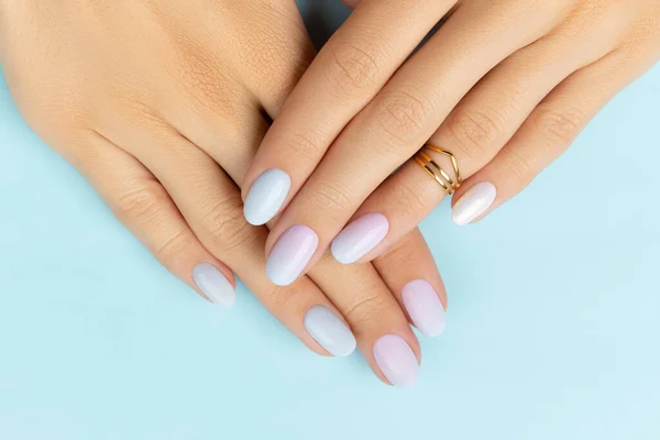 Mujeres manos con manicura de moda sobre fondo azul. Diseño de uñas de verano —  Fotos de Stock
