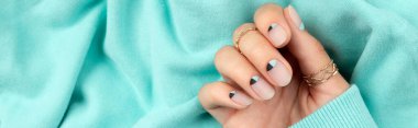 Çıplak ve mavi tırnak tasarımlı güzel bir kadın eli.