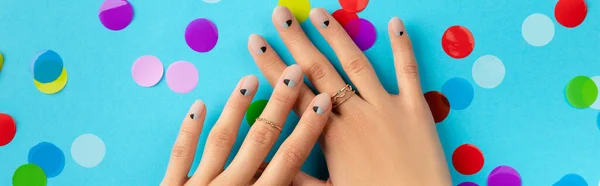 Womans hands with colorful confetti over blue background. — Stock Photo, Image