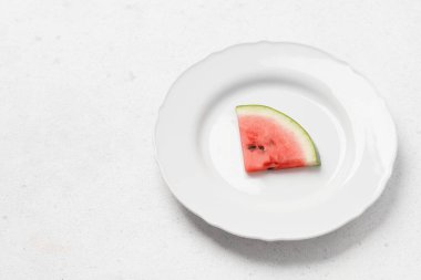 Gri arka planda tohumları olan karpuz dilimi. Taze meyve tabağında