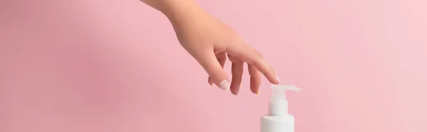 Groomed womans hand touch bottle of lotion or cream — ストック写真