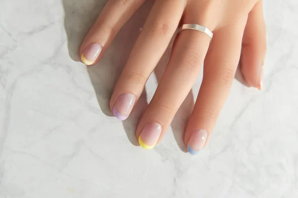 Mooie vrouwen hand met lente zomer nagel ontwerp op marmer grijze achtergrond — Stockfoto