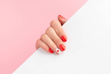 Beyaz kağıt tutan manikürlü kadınlar. Moda Sevgililer Günü Tırnak Tasarımı