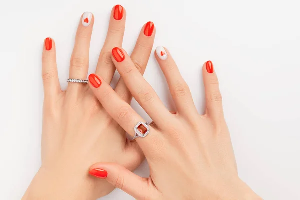 Kobiece ręce z modnym czerwonym manicure na białym tle. Letni projekt paznokci z sercem — Zdjęcie stockowe