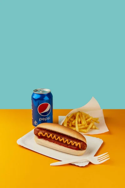 KIEV, UKRAINE - SEPTEMBER 16, 2021. Classic hot dog with french fries and Pepsi cola on orange table. Restaurant menu — Fotografia de Stock