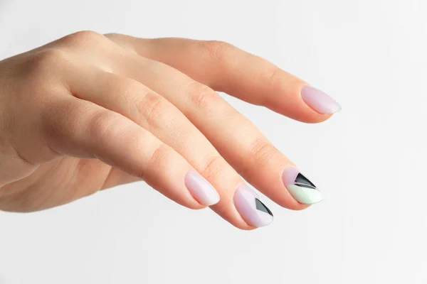 Fermez la main des femmes avec un design d'ongles créatif sur fond gris — Photo