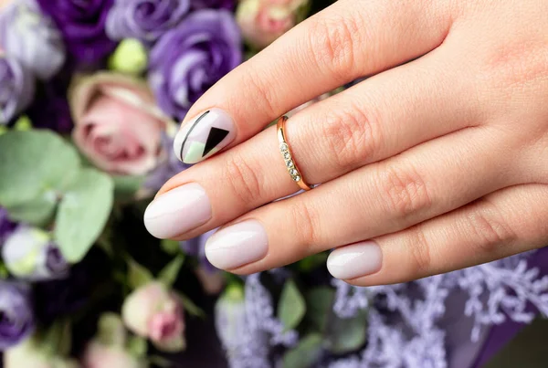 De cerca la mano de las mujeres con diseño creativo de uñas en el fondo de la flor — Foto de Stock