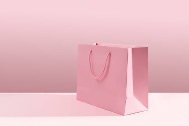Pembe arka planda kağıt alışveriş torbası. Alışveriş teslimatı konsepti. Paketleme şablonu maketi