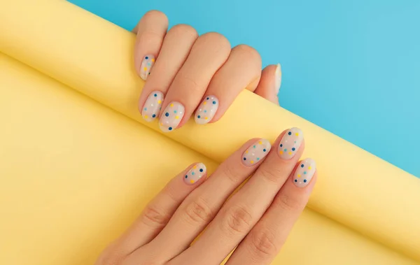 Vrouwen Handen Met Trendy Polka Dot Zomer Manicure Blauwe Achtergrond — Stockfoto