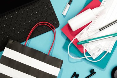 Mavi Masa 'da klavye kırtasiyesi ve el dezenfektanı. Düz Yatay Üst Görünüm Okula Dönüş Yeni Normal Kavram