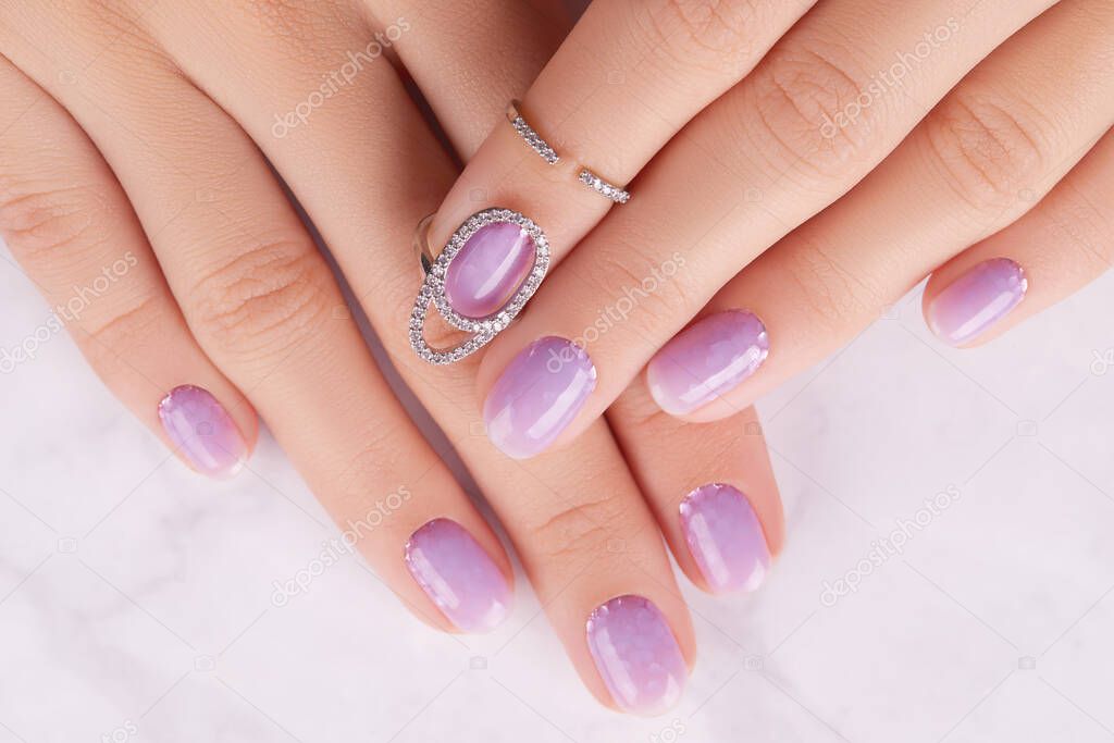 Womans hands with trendy lavender manicure. Spring summer nail design. Fashion beauty salon concept