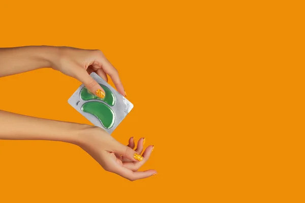 Womans Hands Holding Eye Patches Orange Backgound Face Care Beauty — ストック写真