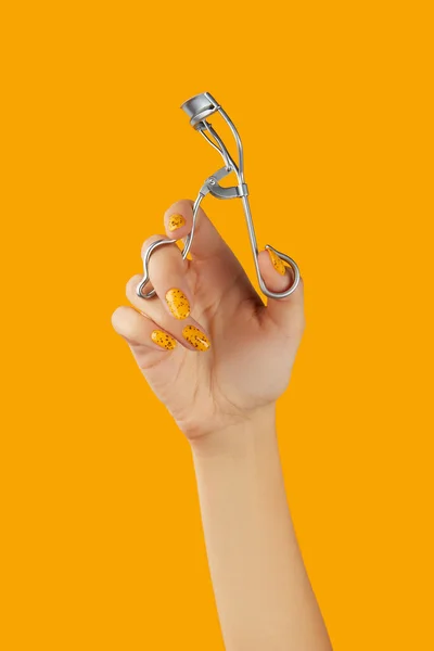 Eyelash Curler Females Hand Orange Background Beauty Salon Concept — Stock fotografie