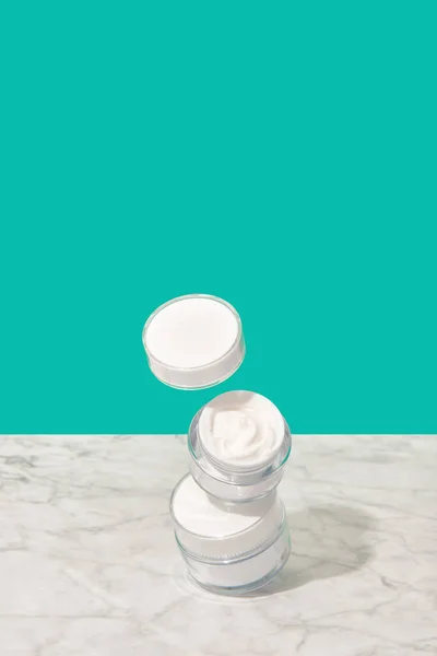 Balancing Jars Cosmetic Cream Turquoise Background Body Care Beauty Treatment — Stock Photo, Image
