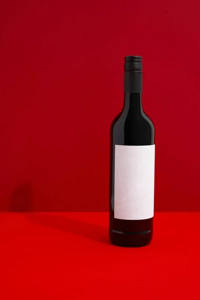 Wine bottle with blank label. Red wine on creative background with copy space. Product branding mock up.