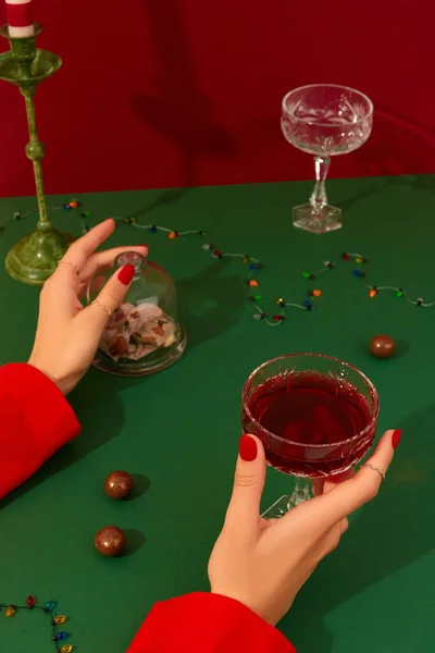 Vánoční Novoroční Kreativní Kompozice Ženskýma Rukama Sklenicí Červeného Šampaňského Zeleném — Stock fotografie