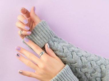 Kadınların elleri lavantalı ve gümüş tırnaklı. Güzellik tedavisi. Manikür, pedikür tasarım eğilimleri