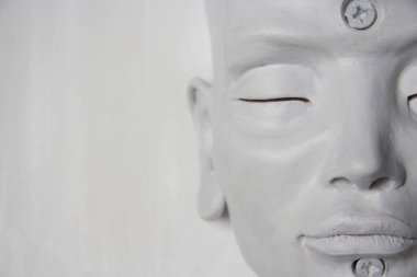 Kapalı gözlerle rüya gören beyaz heykelin yüzü. Beyaz arka planda kadın özellikleri olan beyaz tenli..