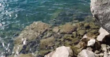 Uçurumlardaki gölün şeffaf turkuaz suyu.