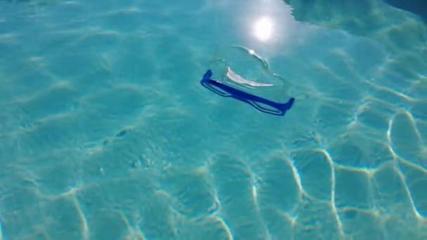 澄んだ水が浮かんでいるスイミングマスク 澄んだ水の上の光の反射 スローモーション ビデオ4K — ストック動画