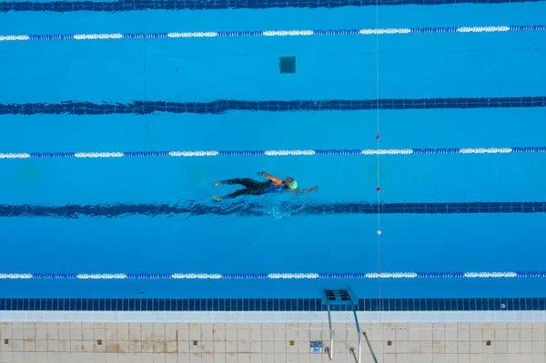 Temiz mavi su ve açık hava şeritleriyle yüzme havuzunda sportif yüzücü eğitimi. Spor merkezinde eğitim..