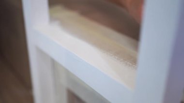 Evdeki yenileme işlemi sırasında kimliği belirsiz bir kadın merdivenlere beyaz bant yapıştırıyor.