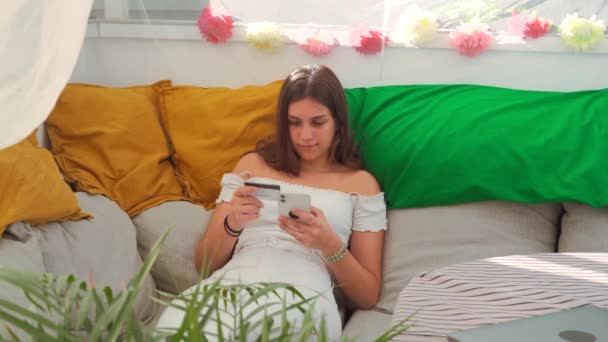 Joven Mujer Contenido Sentado Sofá Haciendo Pago Con Tarjeta Plástico — Vídeos de Stock