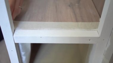 Evdeki yenileme işlemi sırasında kimliği belirsiz bir kadın merdivenlere beyaz bant yapıştırıyor.