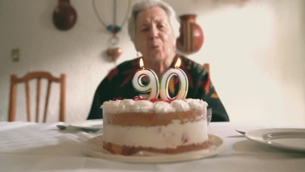 老年妇女在生日蛋糕上吹蜡烛 然后与亲戚在家里庆祝90周年纪念日时拍手 — 图库视频影像