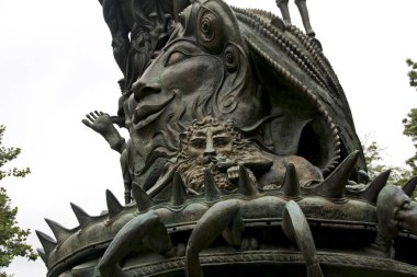 Parte de una escultura con rostros y figuras sobre una fuente del jardin de una iglesia en la ciudad de Nueva York