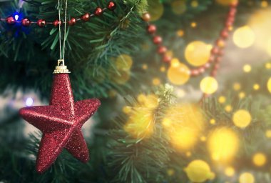 Kırmızı Noel süsleme yıldızı ağaçta sönmüş ışıklarla.