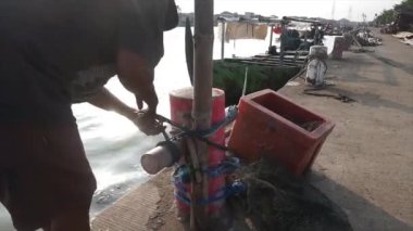 Geleneksel balıkçı teknesini limana bağlıyor, balıkçı teknesi.