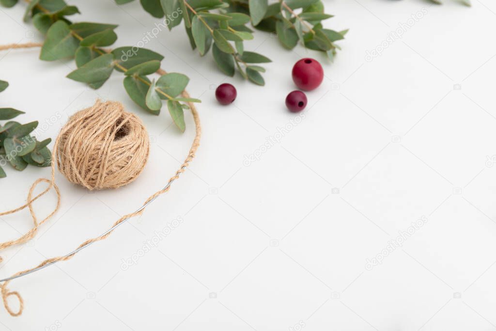 Beads, twine and eucalyptus. The process of creating a decorative autumn wreath. High quality photo