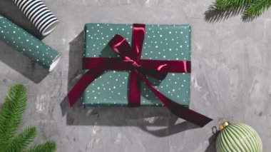 İçinde dallar, ambalaj kağıtları ve Noel oyuncakları ile süslenmiş gri arka planda yeşil ekran olan Noel hediyesinin paketini açmak - Hareket Animasyonunu Durdur