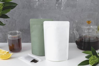 Çay için yeşil ve beyaz karton paket. Gri arka planda çay markası ve ambalaj modeli. Yüksek kalite fotoğraf