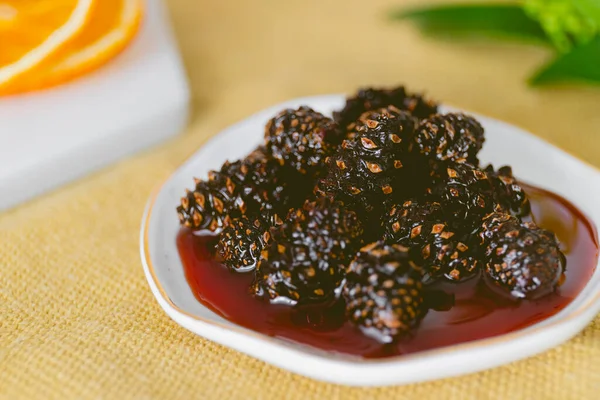 Genç kozalaklar reçel. Faydalı ve lezzetli bir tatlı. Sarı arka planda geleneksel Sibirya tatlısı. Yüksek kalite fotoğraf