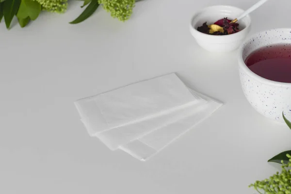 空的茶叶滤清器 杯子中的茶和干芙蓉叶放在白桌上 高质量的照片 — 图库照片
